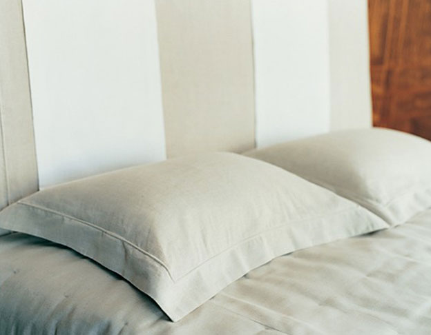 Hotel bed detail: fire proof grey linen and white Egyptian cotton runner